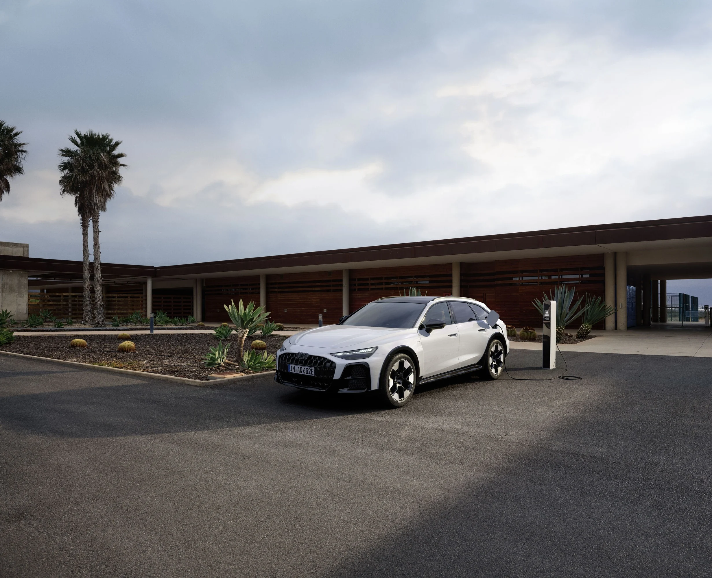 O Audi A6 allroad e-hybrid junto a um posto de carregamento.