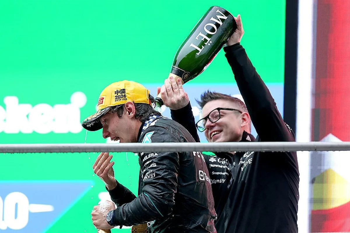 Andrea Kimi Antonelli celebra no pódio do Grande Prémio da China de 2026 com Peter Bonnington. Não é uma imagem da academia de jovens pilotos.