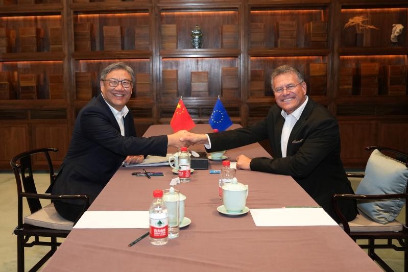 Aperto de mão entre Maroš Šefčovič e Wang Wentao, ministro do Comércio da China, em Pequim. Não mostra o anúncio da redução.